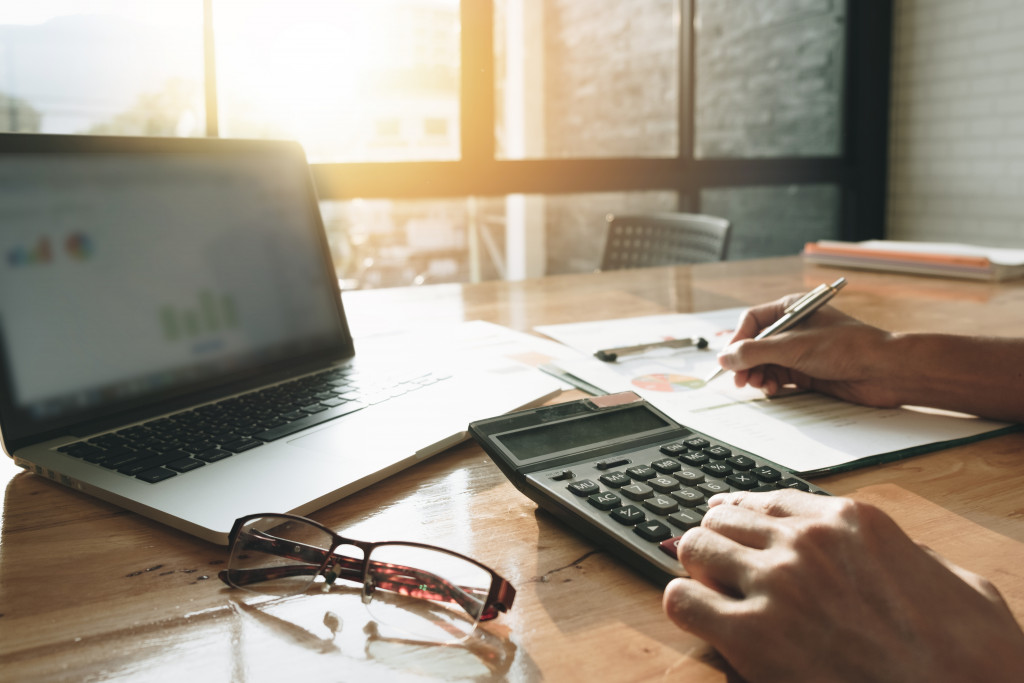 man working on a budget using a calculator