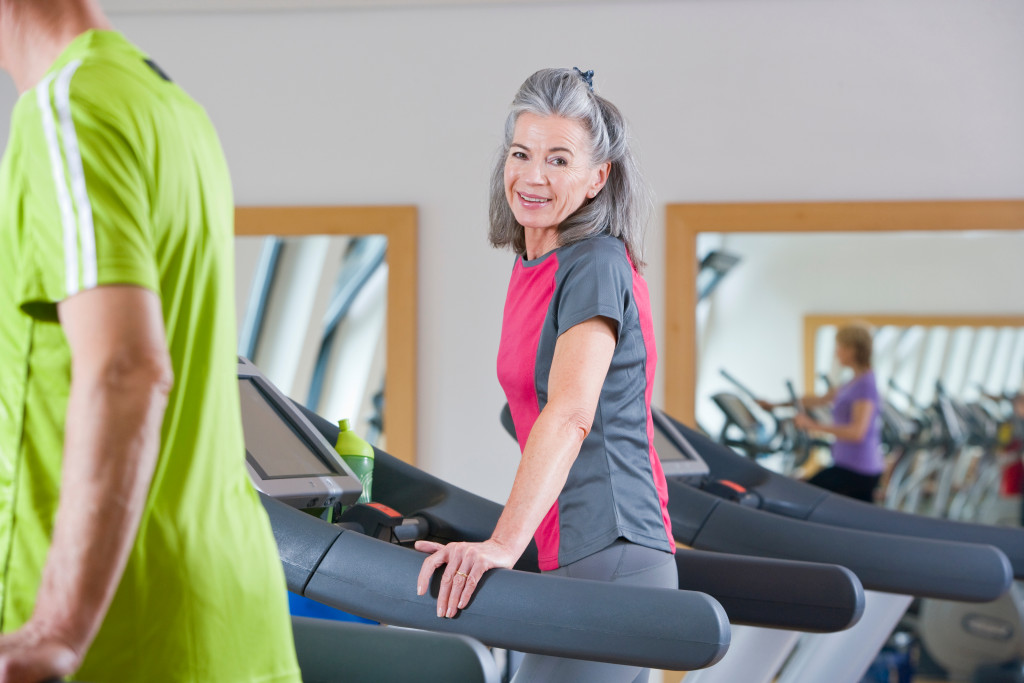 gray-haired senior exercising on a treadmill 